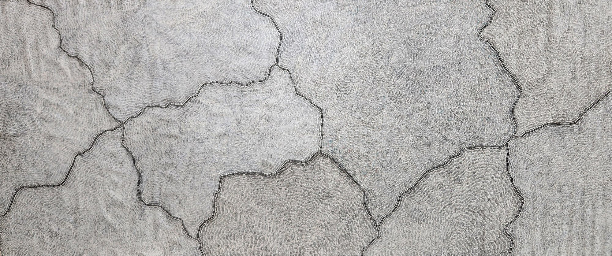 Large silver and grey dotted canvas crossed by dark forked lines resembling lightning strikes and cracked earth seen from above.
